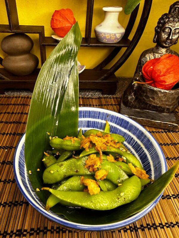 A bowl of steamed edamame beans sprinkled with salt, a classic Japanese starter