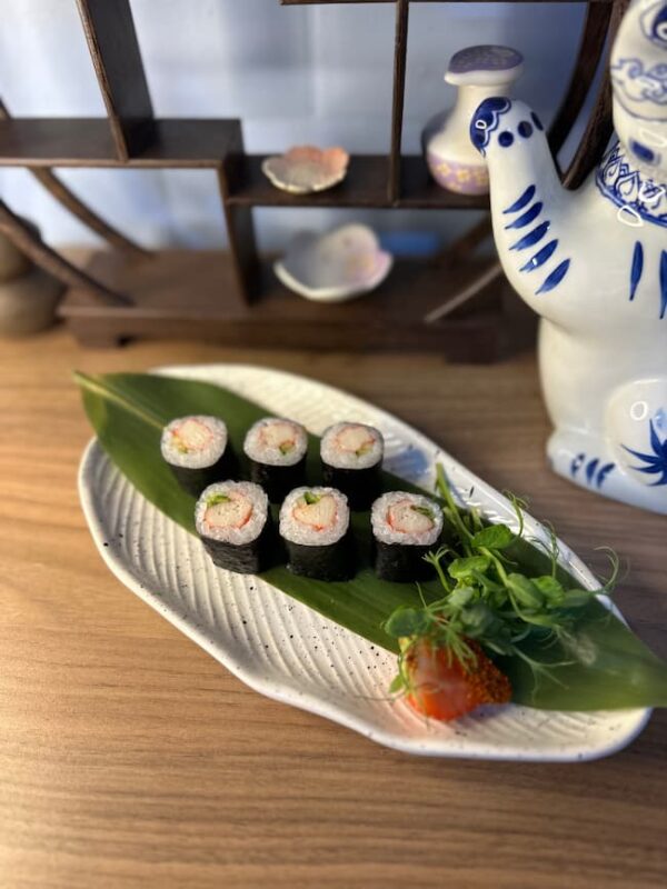 Artful presentation of Maki Crab sushi in Edinburgh, served on a leaf on an elegant white plate.