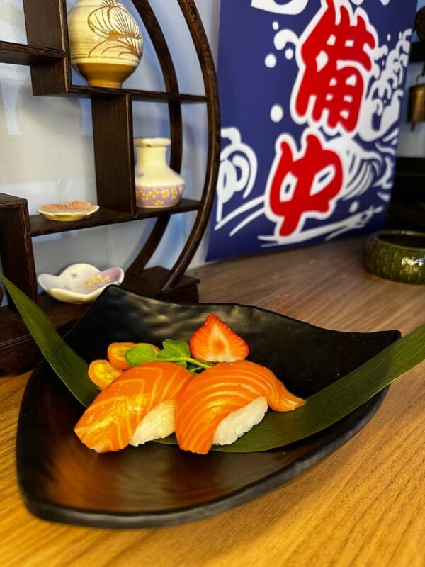 Close-up of Nigiri Salmon with delicate wasabi hint, set against a backdrop of Japanese decor.