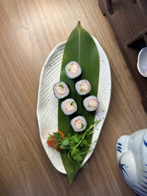 Edinburgh Maki Crab delicacy presented on a leaf over a stylish plate, Japanese pottery beside