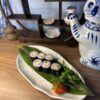 Edinburgh Maki Crab sushi on white textured plate with green leaf and Japanese decor.