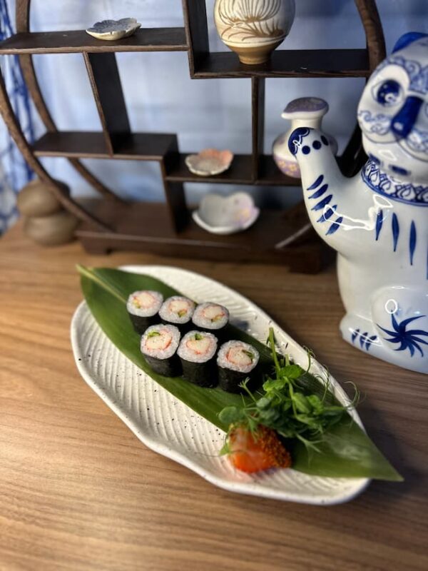 Edinburgh Maki Crab sushi on white textured plate with green leaf and Japanese decor.