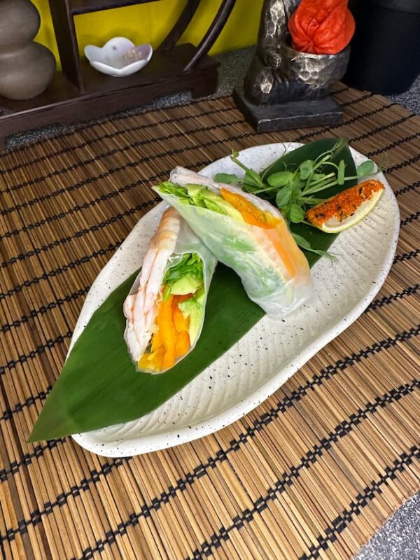 Edinburgh shrimp spring roll with crisp vegetables on an elegant white plate with a neutral background