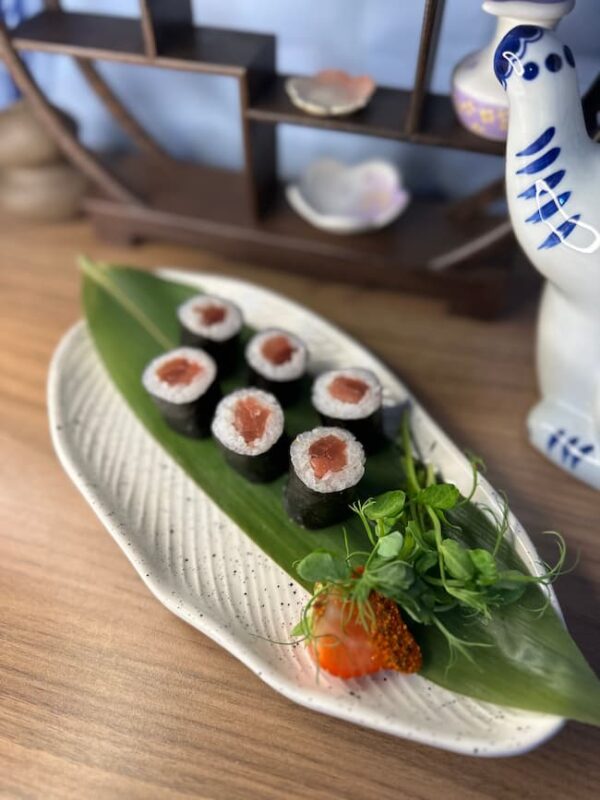 Edinburgh's Maki Salmon, a delicious sushi snack, presented with fresh garnish on ceramic plate.