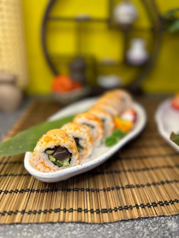 Elegant California Classic Tobiko sushi garnished with flying fish roe on a leaf plate, showcasing Edinburgh's culinary finesse