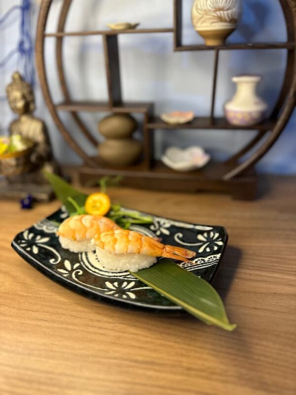 Elegant Nigiri Shrimp on a decorative black plate, perfect for a sushi snack in Edinburgh.