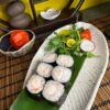 Fresh Maki Shrimp sushi on a leaf-lined plate with vibrant salad garnish, served in an Edinburgh sushi restaurant