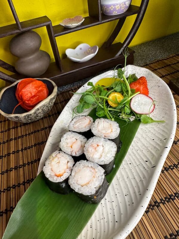 Fresh Maki Shrimp sushi on a leaf-lined plate with vibrant salad garnish, served in an Edinburgh sushi restaurant