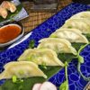 Freshly prepared Gyoza Vegetables served on a blue-patterned plate with a side of sauce in Edinburgh