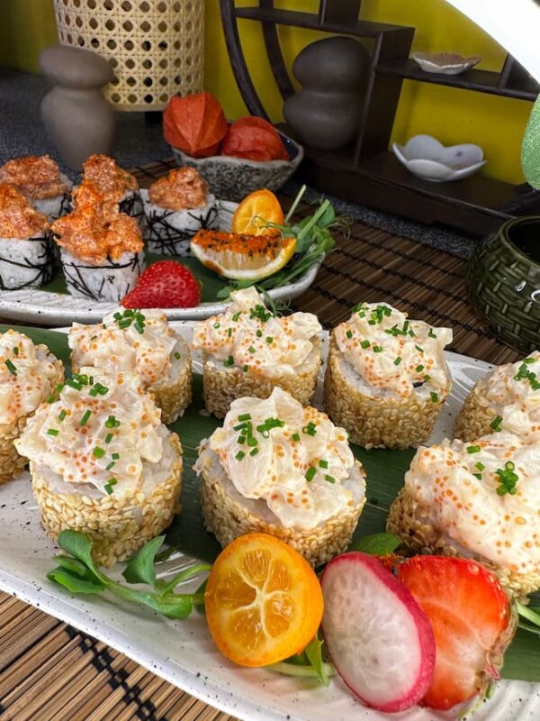 Gourmet Tartarus with Sea Scallop sushi garnished with sesame seeds, served with fresh fruits on a traditional bamboo mat in Edinburgh