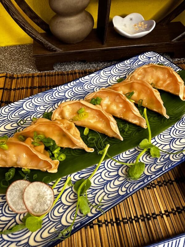 Gyoza Prawn arranged on a leaf on a decorative blue plate, a taste of Edinburgh