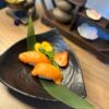 Savor the simplicity of Nigiri Salmon, fresh and inviting on a leaf garnish, perfect for a light lunch.