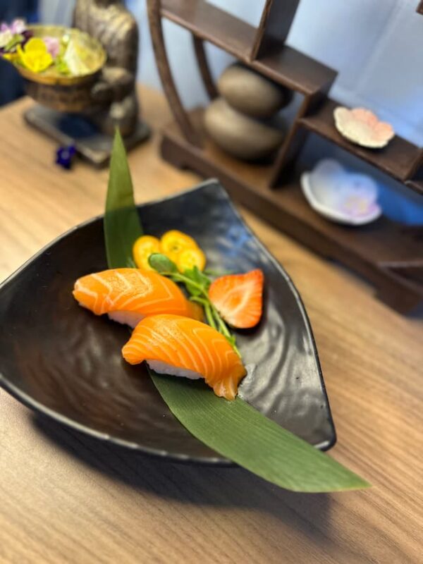 Savor the simplicity of Nigiri Salmon, fresh and inviting on a leaf garnish, perfect for a light lunch.