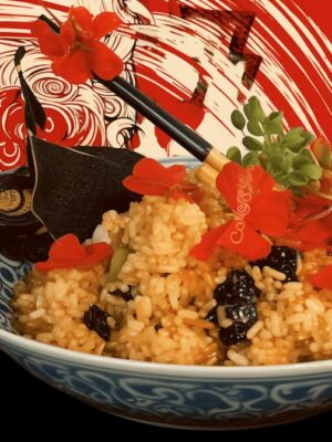 A bowl of rice with herbs and black beans sits elegantly in front of a red and white artistic background, reminiscent of Edinburgh's vibrant art scene, featuring a stylized face.