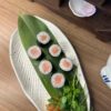 Maki Salmon sushi rolls on a white plate with a green leaf, perfect snack in Edinburgh