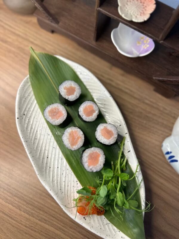 Maki Salmon sushi rolls on a white plate with a green leaf, perfect snack in Edinburgh