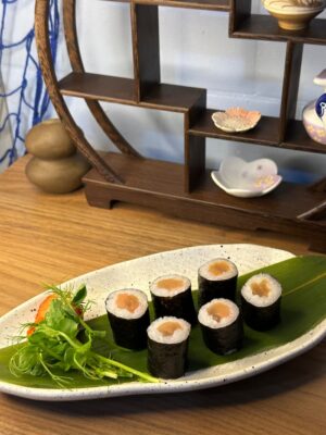 Overhead view of Maki Salmon rolls, a classic Edinburgh sushi snack on a textured plate