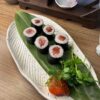 Overhead view of Maki Salmon rolls, a classic Edinburgh sushi snack on a textured plate.