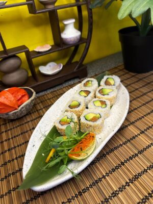 Salmon Avocado Roll sushi arranged on a ceramic plate over a bamboo mat, showcasing fresh avocado and sesame seeds, in Edinburgh sushi restaurant