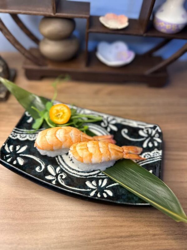 Succulent prawn nigiri served as a refined snack on a beautifully patterned plate in Edinburgh.