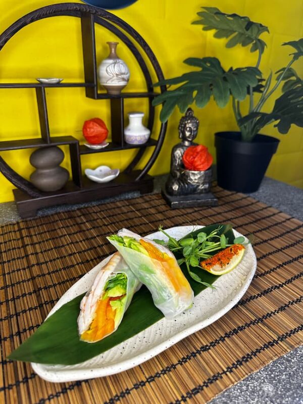 Traditional Edinburgh shrimp spring roll on a bamboo mat with decorative background