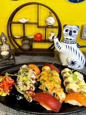 Assorted California Sushi Platter on black plate, featuring nigiri and sesame rolls in Edinburgh