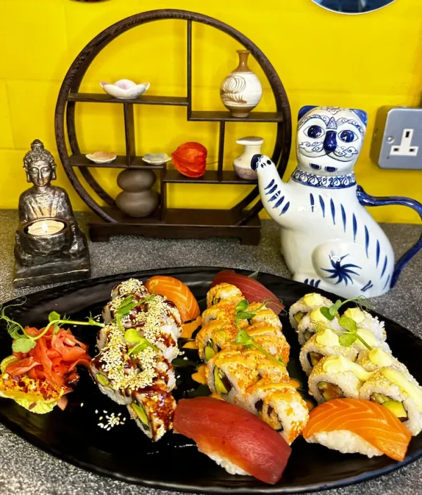 Assorted California Sushi Platter on black plate, featuring nigiri and sesame rolls in Edinburgh