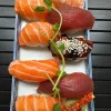 Assorted nigiri sushi set with salmon and tuna on a traditional blue plate in Edinburgh