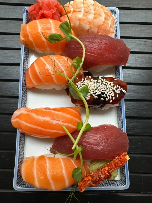 Assorted nigiri sushi set with salmon and tuna on a traditional blue plate in Edinburgh