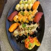 California Sushi Platter beside Buddha statue and Japanese decor, featuring mixed sushi in Edinburgh