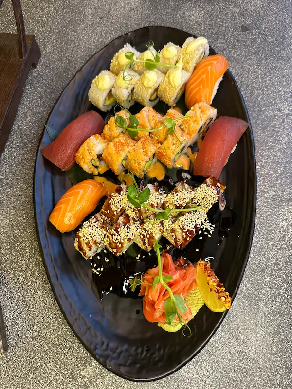 California Sushi Platter beside Buddha statue and Japanese decor, featuring mixed sushi in Edinburgh