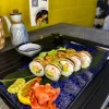 Close-up of Futomaki crab sushi showcasing fresh cucumber, avocado, and spicy sauce garnish, served in Edinburgh