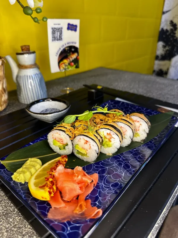 Close-up of Futomaki crab sushi showcasing fresh cucumber, avocado, and spicy sauce garnish, served in Edinburgh