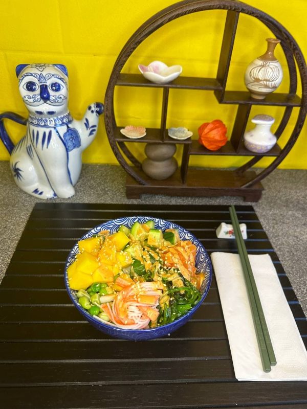 Close-up of vibrant Salmon Poke bowl featuring succulent salmon slices, mango chunks, and a drizzle of nut sauce, perfect for a gourmet meal in Edinburgh