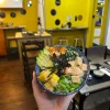 Colorful Vegan Poke bowl featuring a mix of rice, mango, avocado, edamame, and tofu topped with sesame seeds and spicy mayo, served in Edinburgh