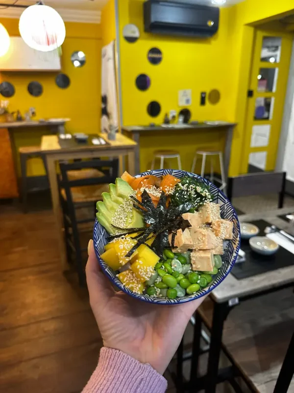 Colorful Vegan Poke bowl featuring a mix of rice, mango, avocado, edamame, and tofu topped with sesame seeds and spicy mayo, served in Edinburgh