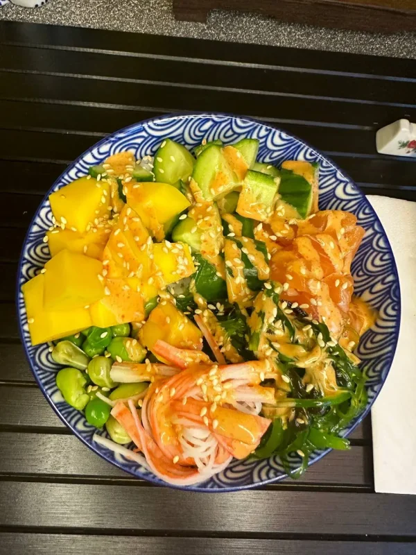 Delicious Salmon Poke bowl with fresh salmon, mango, edamame, and spicy mayo, beautifully served on a traditional Japanese dish in Edinburgh.