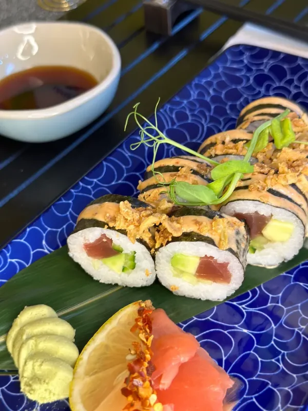 Detail of Futomaki tuna sushi rolls with a focus on the layers of avocado and cucumber, complemented by spicy sauce in Edinburgh