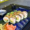 Elegant display of Futomaki crab sushi on a leaf with lemon and spicy toppings, enhancing the dining experience in Edinburgh