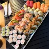 The Imperial feast set features assorted sushi rolls and nigiri on a black placemat with chopsticks and dipping dishes nearby.
