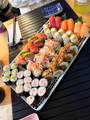 The Imperial feast set features assorted sushi rolls and nigiri on a black placemat with chopsticks and dipping dishes nearby.