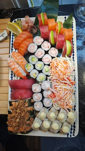 The Imperial feast set features nigiri, sashimi, maki rolls, and crab salad on a rectangular white plate.