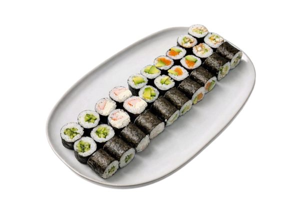 Maki set: A white plate with three rows of assorted vegetable and fish sushi rolls on a white background.