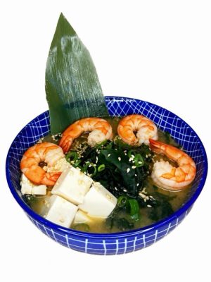 Miso soup with Shrimp served in a blue bowl, with salmon, tofu, seaweed, scallions, sesame seeds, and a leaf garnish.