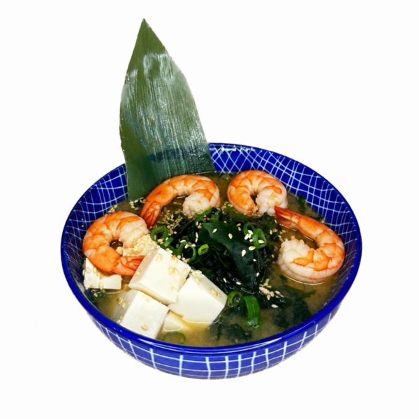 Miso soup with Shrimp served in a blue bowl, with salmon, tofu, seaweed, scallions, sesame seeds, and a leaf garnish.
